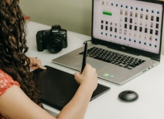 Z 1 zdjęcia do 5 stylów: ćwiczenie kreatywnej obróbki w Photoshopie Kobieta przy laptopie obrabiająca zdjęcia na tablecie graficznym