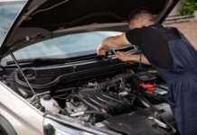 Jak kupić używane auto po flotowe i nie żałować – praktyczny poradnik dla kierowców Mechanik naprawia silnik samochodu na zewnątrz w słoneczny dzień