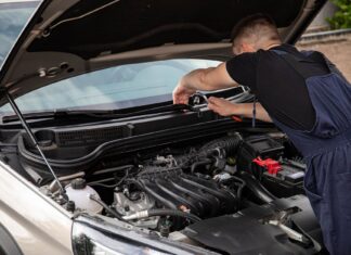 Jak kupić używane auto po flotowe i nie żałować – praktyczny poradnik dla kierowców Mechanik naprawia silnik samochodu na zewnątrz w słoneczny dzień