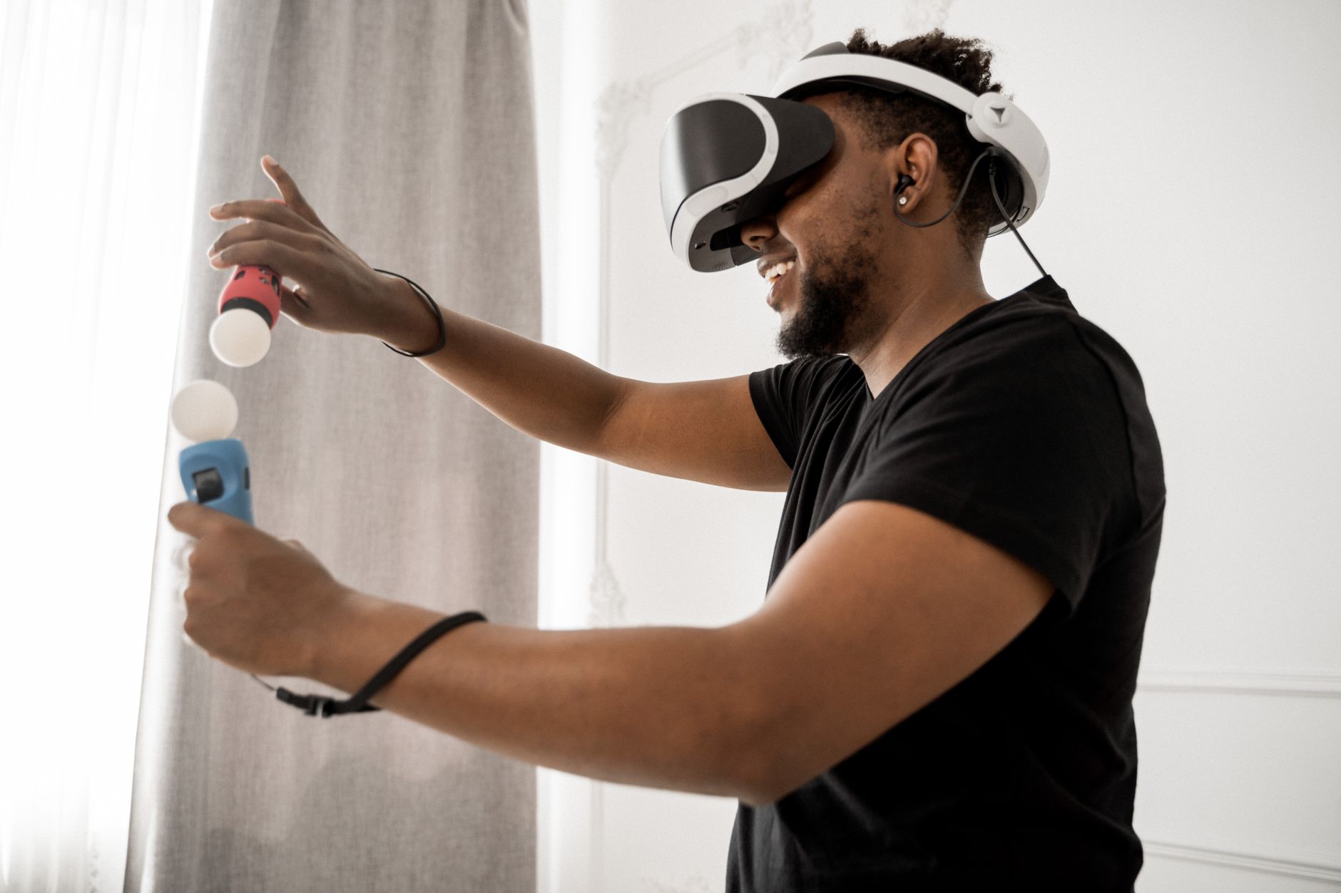 Mężczyzna w goglach VR z kontrolerami tworzy cyfrowy mural indoors