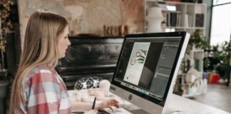 Kobieta pracuje na tablecie graficznym przy biurku w nowoczesnym biurze