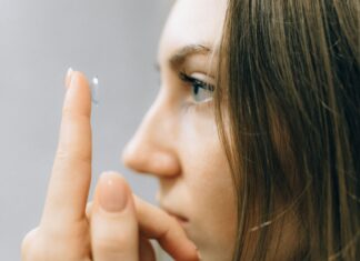 Soczewki kontaktowe dla wrażliwych oczu – jak dobrać komfortowe rozwiązanie z pomocą optometrysty Młoda kobieta zakłada soczewkę kontaktową na oko z bliska