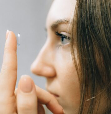 Soczewki kontaktowe dla wrażliwych oczu – jak dobrać komfortowe rozwiązanie z pomocą optometrysty Młoda kobieta zakłada soczewkę kontaktową na oko z bliska